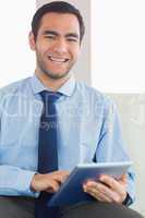 Smiling classy businessman using tablet pc