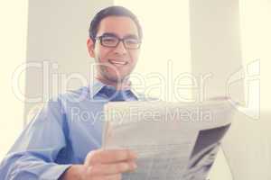 Happy man looking at camera and holding a newspaper