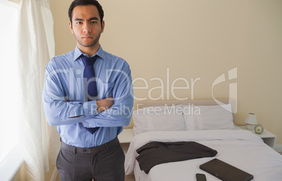 Serious man looking at camera and standing with crossed arms