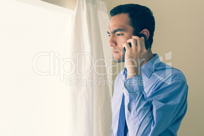 Irritated man calling someone with a mobile phone and looking ou