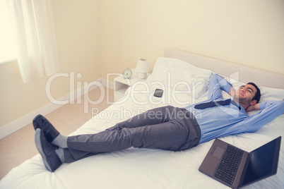 Pleased man relaxing on his bed