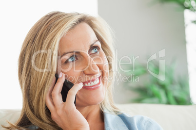 Smiling woman calling someone with her mobile phone