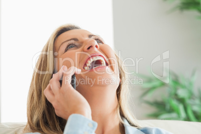 Laughing woman calling someone with her mobile phone