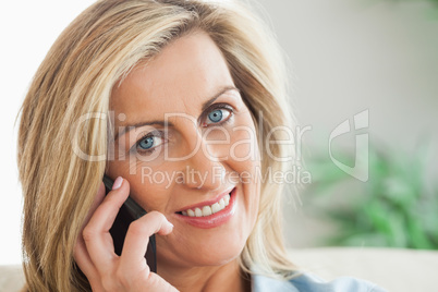 Smiling woman calling someome with her mobile phone