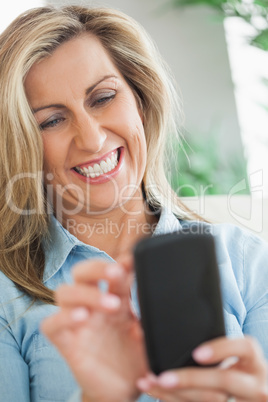 Happy woman typing on her mobile phone Happy woman typing on her mobile phone