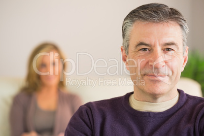 Smiling man with his wife in the background