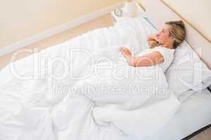 Smiling woman lying on her bed