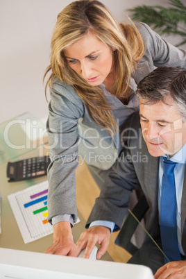 Colleagues looking a computer in an office