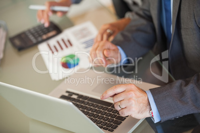 People in an office looking a laptop