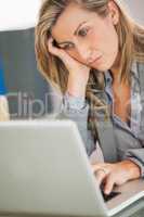 Jaded businesswoman looking at her laptop in an office