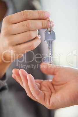 Estate agent giving house key to customer