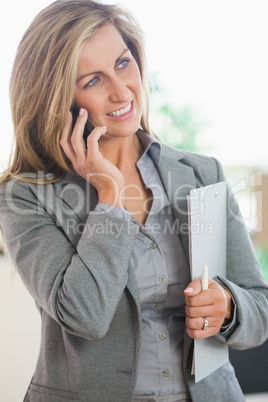 Smiling woman calling someone with her mobile phone