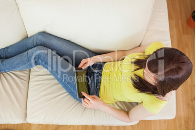 Brunette using her tablet pc on a sofa