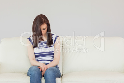 Depressed girl sitting on a sofa