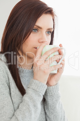 Thinking girl drinking a cup of coffee