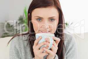 Smiling girl drinking a cup of coffee