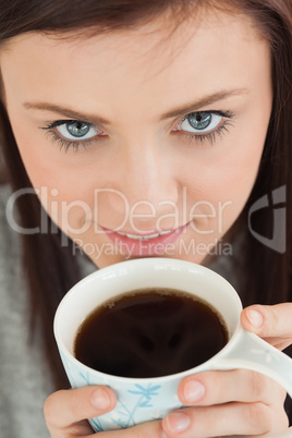 Smiling girl drinking a cup of coffee