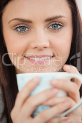 Smiling girl holding a cup of coffee