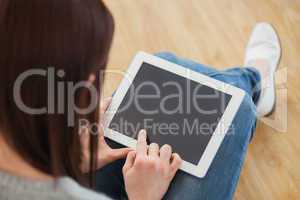 Girl using a tablet pc sitting on the floor