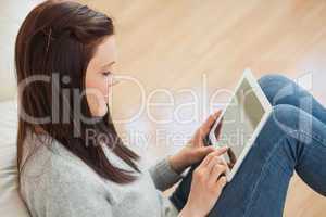 Girl using a tablet sitting on the floor