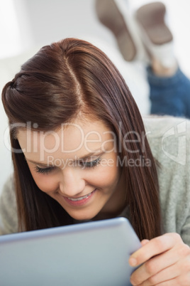 Content girl using a tablet pc on a sofa
