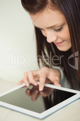 Relaxing girl looking and using a tablet pc on a sofa