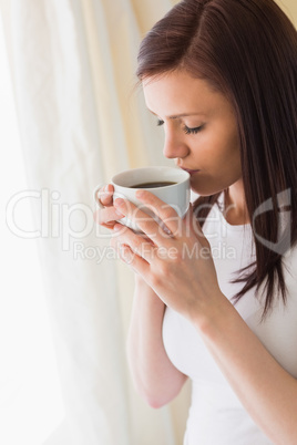 Thoughtful girl holding a cup of coffee eyes closed