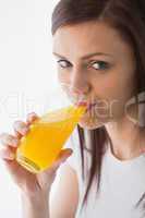 Smiling girl drinking a glass of orange juice