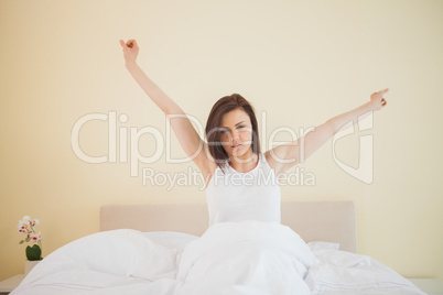 Awakened girl stretching in her bed