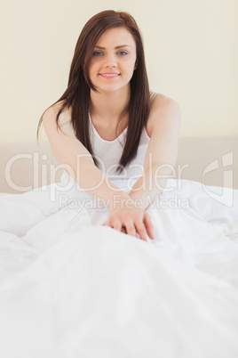 Awakened girl sitting in her bed looking at camera