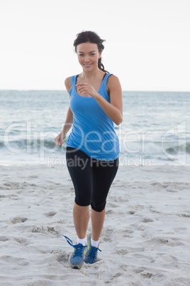 Sporty woman running at the beach