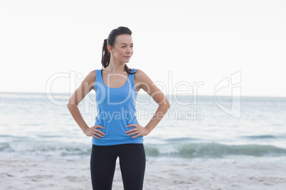 Happy brunette woman standing in front of the sea