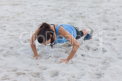 Woman doing push ups at beach