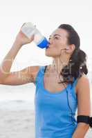 Woman drinking bottled water after doing sports