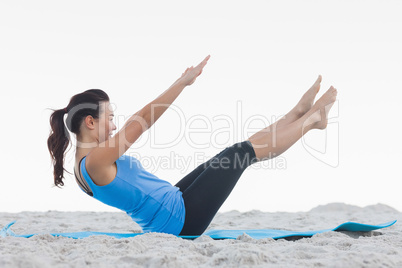 Woman doing pilates on exercise mat