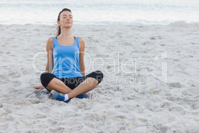 Brunette woman sitting after sport at beach