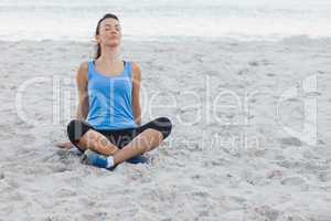 Brunette woman sitting after sport at beach
