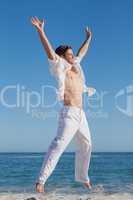 Attractive man jumping on beach