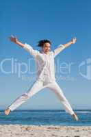 Happy woman jumping on the beach