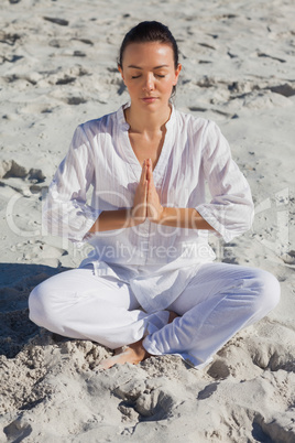 Concentrated woman practicing yoga on the beach