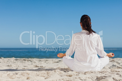 Woman doing yoga sitting back to camera