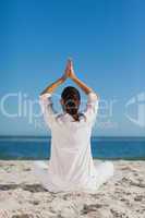 Brunette woman sitting back to camera practicing yoga