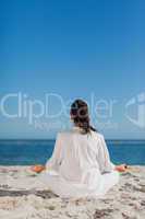 Woman sitting back to camera doing yoga