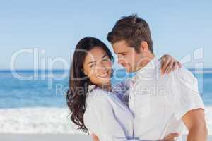 Young couple embracing and posing on the beach
