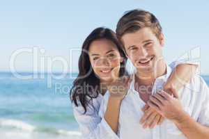 Cheerful couple embracing on the beach