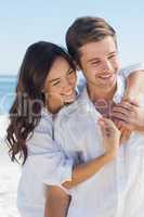 Smiling couple embracing each other on the beach