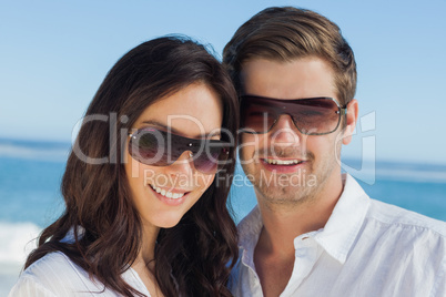 Smiling couple wearing sunglasses and looking at camera