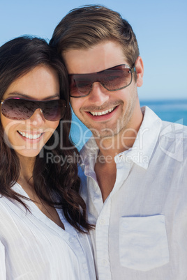 Happy couple wearing sunglasses and smiling at camera