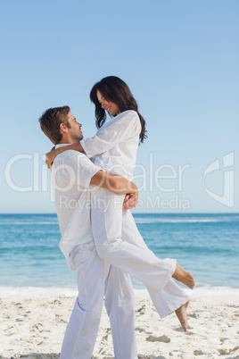 Happy man holding woman in arms