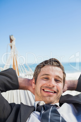 Smiling businessman relaxing in hammock